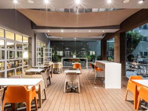 a restaurant with tables and chairs and a cafeteria at Novotel Setubal in Setúbal