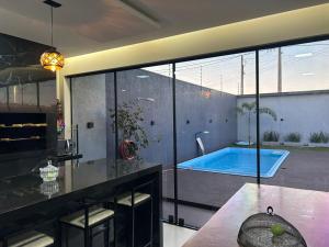 a bathroom with a swimming pool and a large glass window at Espaço aconchegante com piscina e area gourmet in Foz do Iguaçu