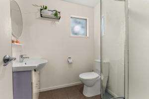 Waipu CoveTreetop Break - Waipu Cove Holiday Home的浴室里有马桶、洗手池和淋浴。 更多18张照片