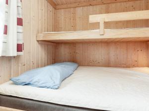 Letto a castello in una cabina di legno con cuscino di Cabin in camping resort with heating a Sønder Rubjerg
