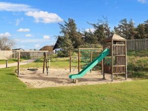 un parco giochi con scivolo verde di vast cabin in camping resort a Sønder Rubjerg