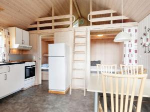 una camera con letto a soppalco e una cucina con tavolo di vast cabin in camping resort a Sønder Rubjerg