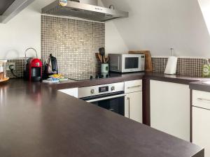 eine Küche mit weißen Schränken und einer Arbeitsplatte in der Unterkunft Sandbourne in Bournemouth