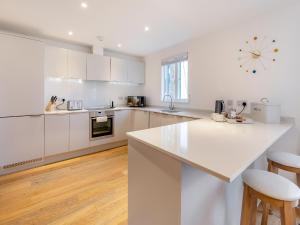 uma cozinha com armários brancos e uma bancada branca em Lodge 74 Una em Carbis Bay