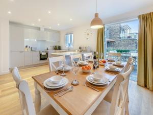 uma cozinha e sala de jantar com mesa e cadeiras de madeira em Lodge 74 Una em Carbis Bay