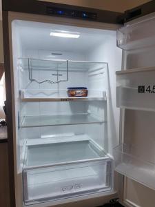 an empty refrigerator with its door open with a bowl in it at JB Guest Rooms in Walvis Bay