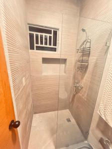 a shower with a glass door and a window at El descanso in Higuey +15 photos
