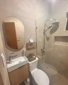 a bathroom with a toilet and a sink and a mirror at El descanso in Higuey