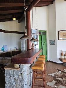 a kitchen with a stone bar with stools at Quarto com suite no Rancho São Francisco de Assis in Morretes
