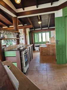 a kitchen with green cabinets and a stove at Quarto com suite no Rancho São Francisco de Assis in Morretes