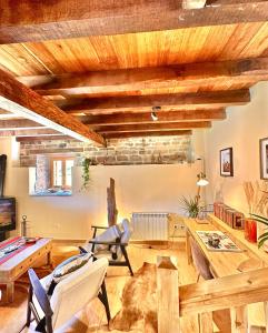 ein Wohnzimmer mit Holzdecken und Holzmöbeln in der Unterkunft Cabaña Los Caballos 