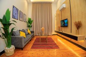 Una sala de estar con un sofá y un televisor en The KMT Collection Hotel, en El Cairo