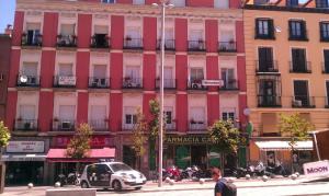 
a street scene with cars and a building at Hostal Santo Domingo in Madrid
