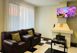 a living room with a brown couch and a fireplace at Mansion del Bosque with Jacuzzi 6 Bedroom 5 Bath in Baños
