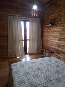 Un dormitorio con una cama y una pared de madera. en Complejo de Cabañas Pura Vida, en Balneario Reta 15 fotos más
