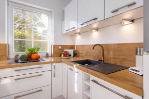 a kitchen with white cabinets and a sink at Whg Dynamique in Zingst +17 photos