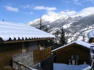 a house with snow on the roof with mountains at Chalet in Villarodin near Lake in La Norma
