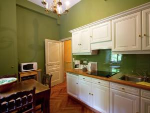 cocina con paredes verdes y armarios blancos en House in France with Pool and Views, en Serrières-en-Chautagne