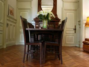 瑟瑞尔恩尚特Charming house in Serrières-en-Chautagne的餐桌、椅子和一瓶鲜花