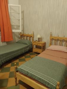 una camera da letto con due letti e un tavolo con una lampada di Dpto 2 personas a Villa María