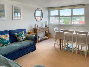 ein Wohnzimmer mit einem blauen Sofa und einem Tisch in der Unterkunft Sandbourne in Bournemouth