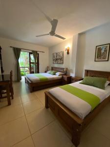 a bedroom with two beds and a ceiling fan at Camali Hotel in Santa Marta +60 photos