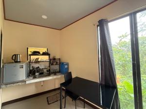 une cuisine avec une table, un évier et une fenêtre dans l'établissement R&C Transient Extension, à El Nido