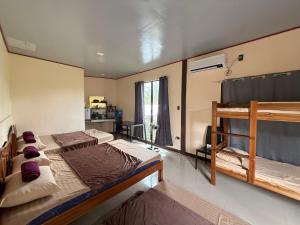 une chambre avec deux lits superposés et une cuisine dans l'établissement R&C Transient Extension, à El Nido