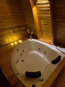 a bath tub in a wooden bathroom with lights at Cabana Encanto da Mata in Santa Maria do Erval +30 photos