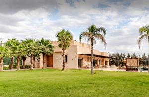 Oulad MazougVilla privée sans vis-à-vis,Padel,Tennis, Five的一栋门前有棕榈树的房子