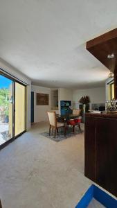 a large living room with a table and chairs at Apartment with jacuzzi and beach club access in Telchac Puerto