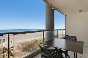 a dining room with a table and chairs and the beach at Belle Escapes - Waves at The Bay in Glenelg