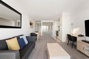 a living room with a couch and a table at Belle Escapes - Waves at The Bay in Glenelg