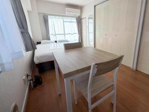 SUNCOURT Komachi في هيروشيما: غرفة بطاولة وسرير وغرفة نوم