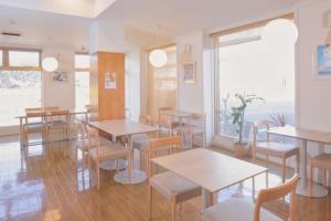 Un restaurante con mesas y sillas y una ventana. en ホテルグリーンヒル御坊駅前, en Gobō
