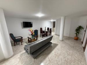 a living room with a couch and chairs and a tv at Confort y seguridad cerca a la basílica en Buga in Buga
