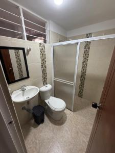 a bathroom with a toilet and a sink and a shower at Confort y seguridad cerca a la basílica en Buga in Buga