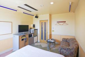 a room with a bed and a tv and a couch at ホテル韮崎インター in Nirasaki