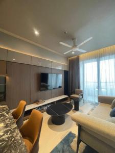 Una sala de estar con un televisor de pantalla plana y un sofá. en Antara Genting by Enigma 2BR, High Floor, en Genting Highlands