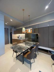 una cocina grande con mesa y sillas. en Antara Genting by Enigma 2BR, High Floor, en Genting Highlands