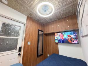 una camera da letto con soffitto e TV a parete di Lux Pod Room a West Palm Beach