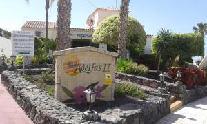 a sign in front of a building with palm trees at Las Adelfas 2 in San Miguel de Abona
