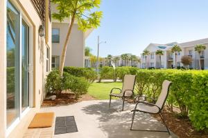twee stoelen op een patio voor een gebouw bij Beachside Bliss - Neptune Nook Unit 1 in Jacksonville Beach
