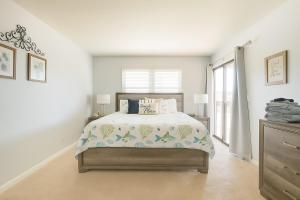een witte slaapkamer met een bed en een raam bij Beachside Bliss - Neptune Nook Unit 1 in Jacksonville Beach
