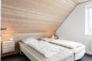 Duas camas num quarto com uma parede de madeira em 0372-Romo-Sonder-Frankel-8 em Havneby