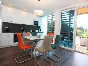 a kitchen and dining room with a table and chairs at Chalet mit Außensauna in Wendorf in Wendorf +6 photos