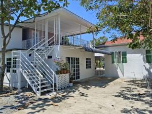 a white house with a staircase in front of it at Princess Iris Homestay in Penampang