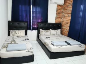 two beds in a room with blue curtains at Princess Iris Homestay in Penampang