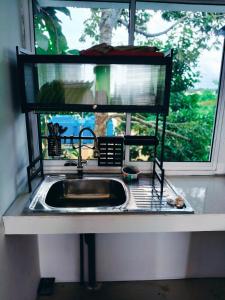 a sink in a kitchen with a window at Princess Iris Homestay in Penampang