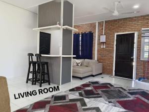 a living room with a couch and a living room with a rug at Princess Iris Homestay in Penampang